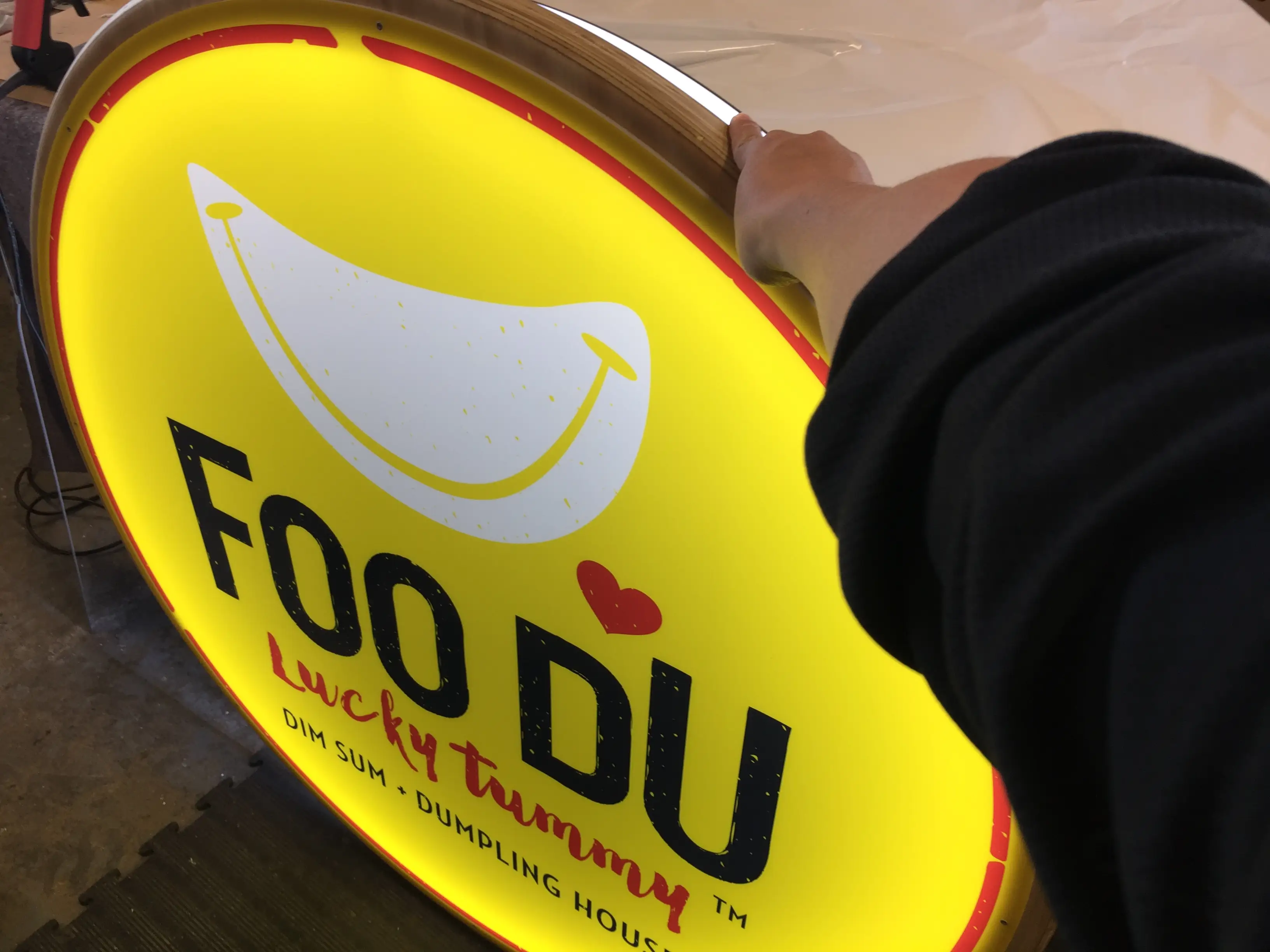 Circular illuminated Foo Du brand sign.