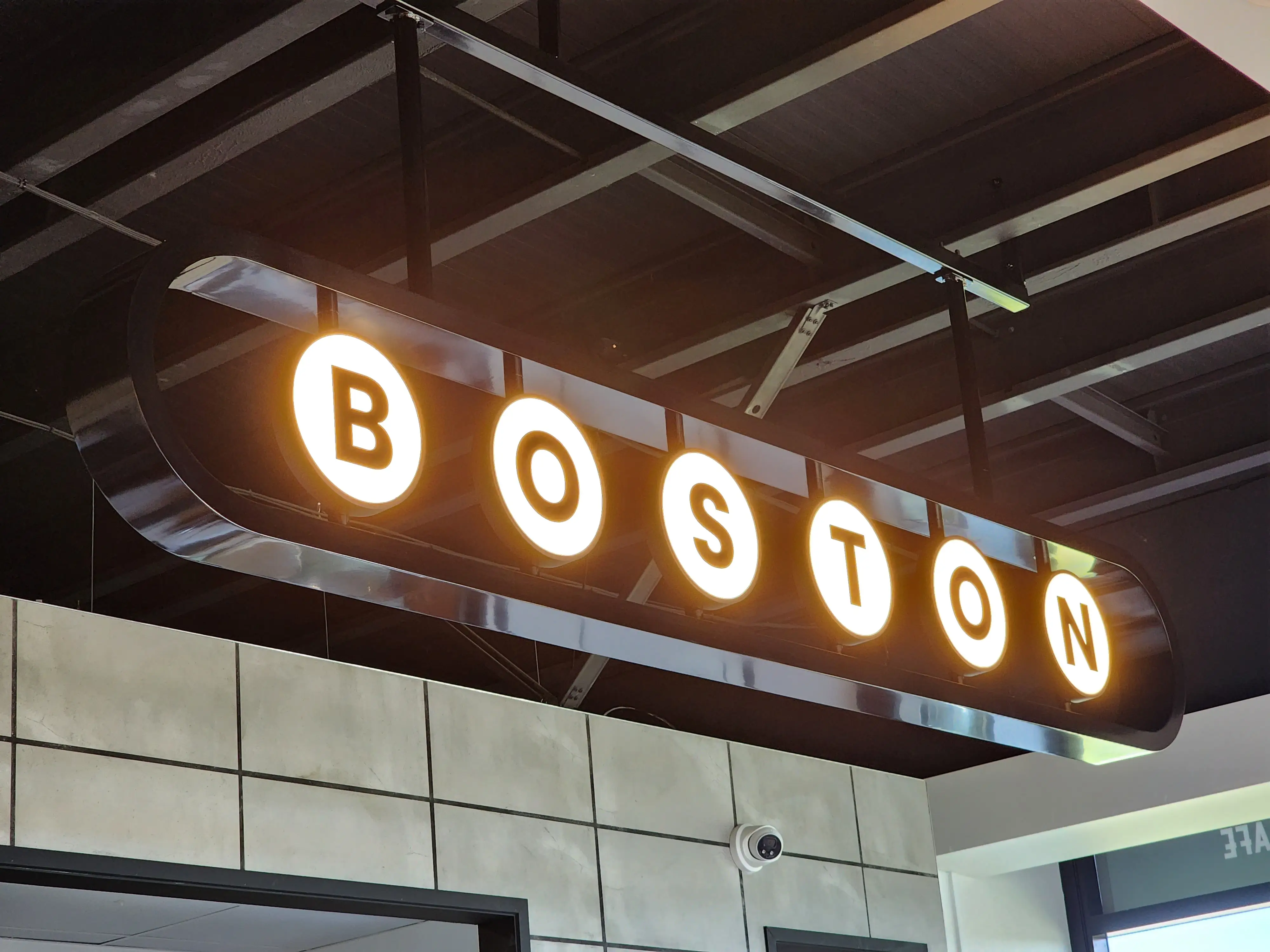 Boston Cafe interior with illuminated overhead identity.