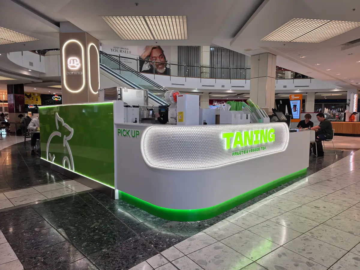 Green-finished customer pickup counter within the shopping centre.