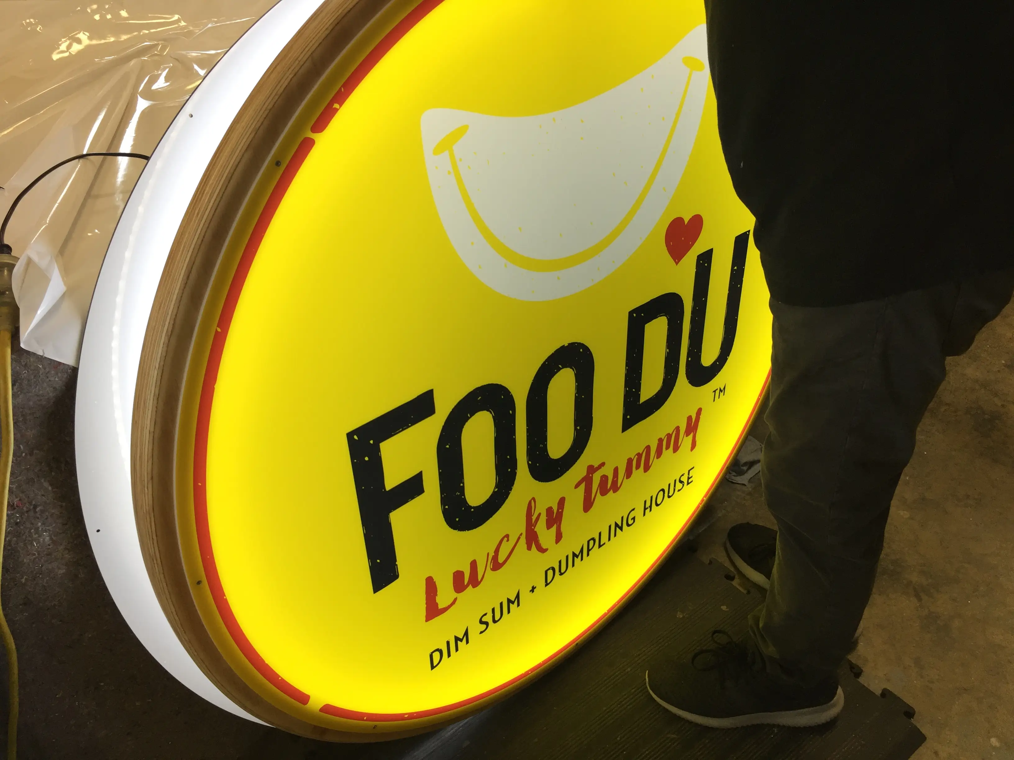 Circular illuminated Foo Du brand sign.