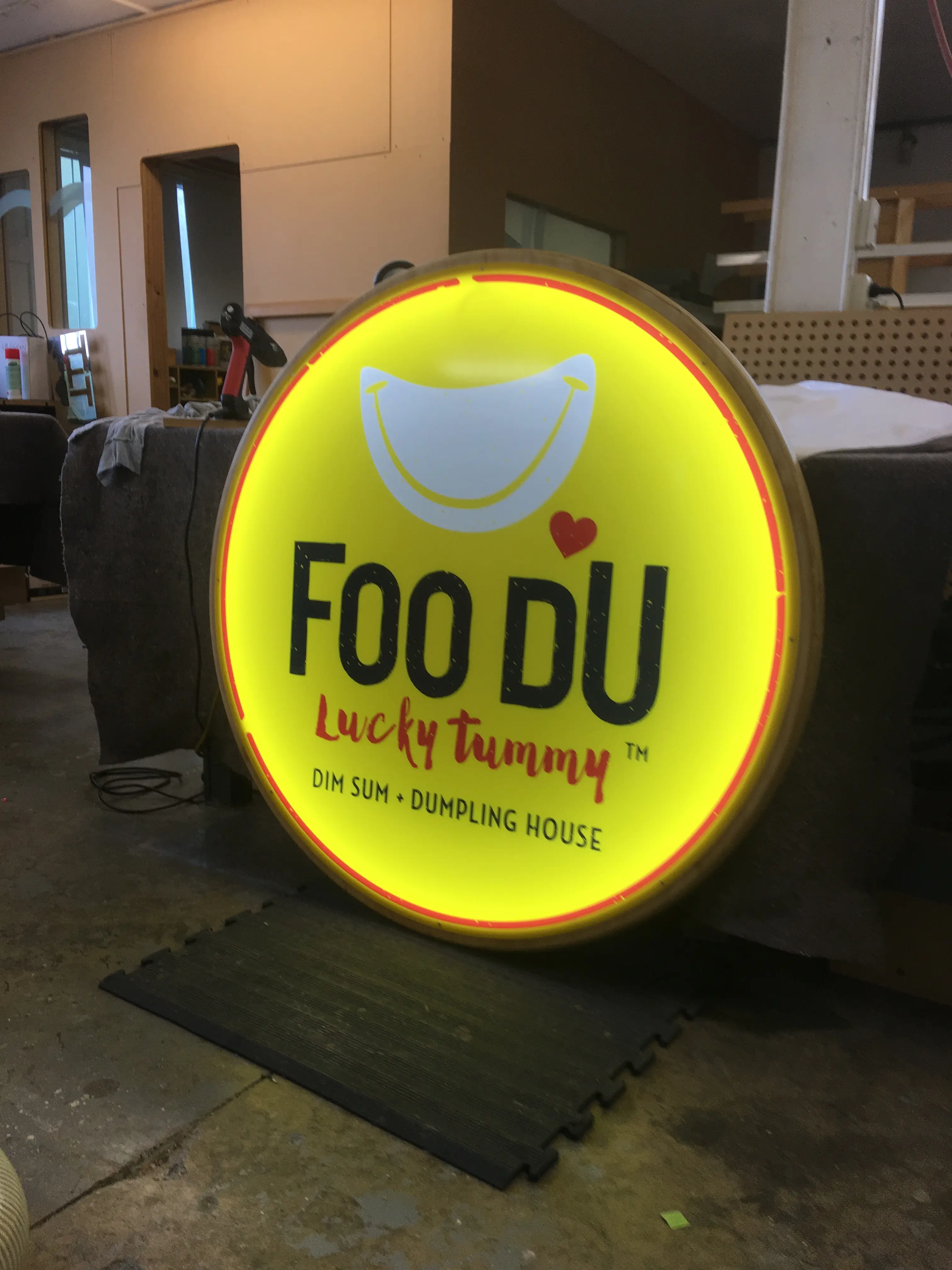 Circular illuminated Foo Du brand sign.