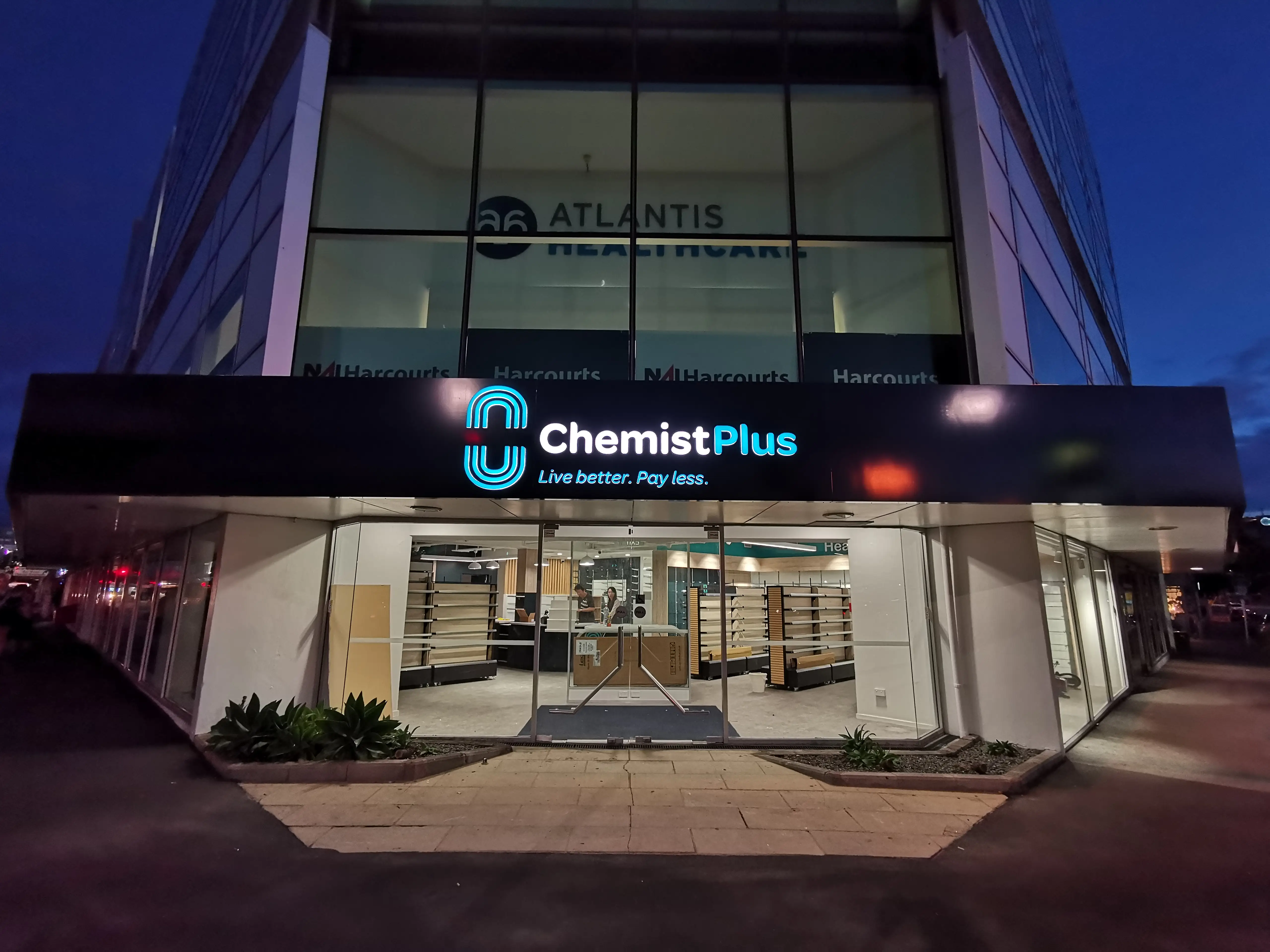 Chemist Plus retail interior with overhead brand signage.
