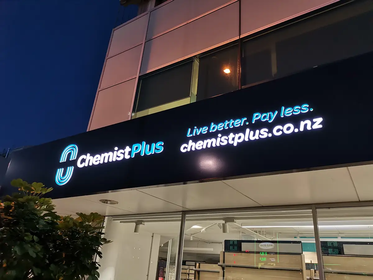 Chemist Plus retail interior with overhead brand signage.