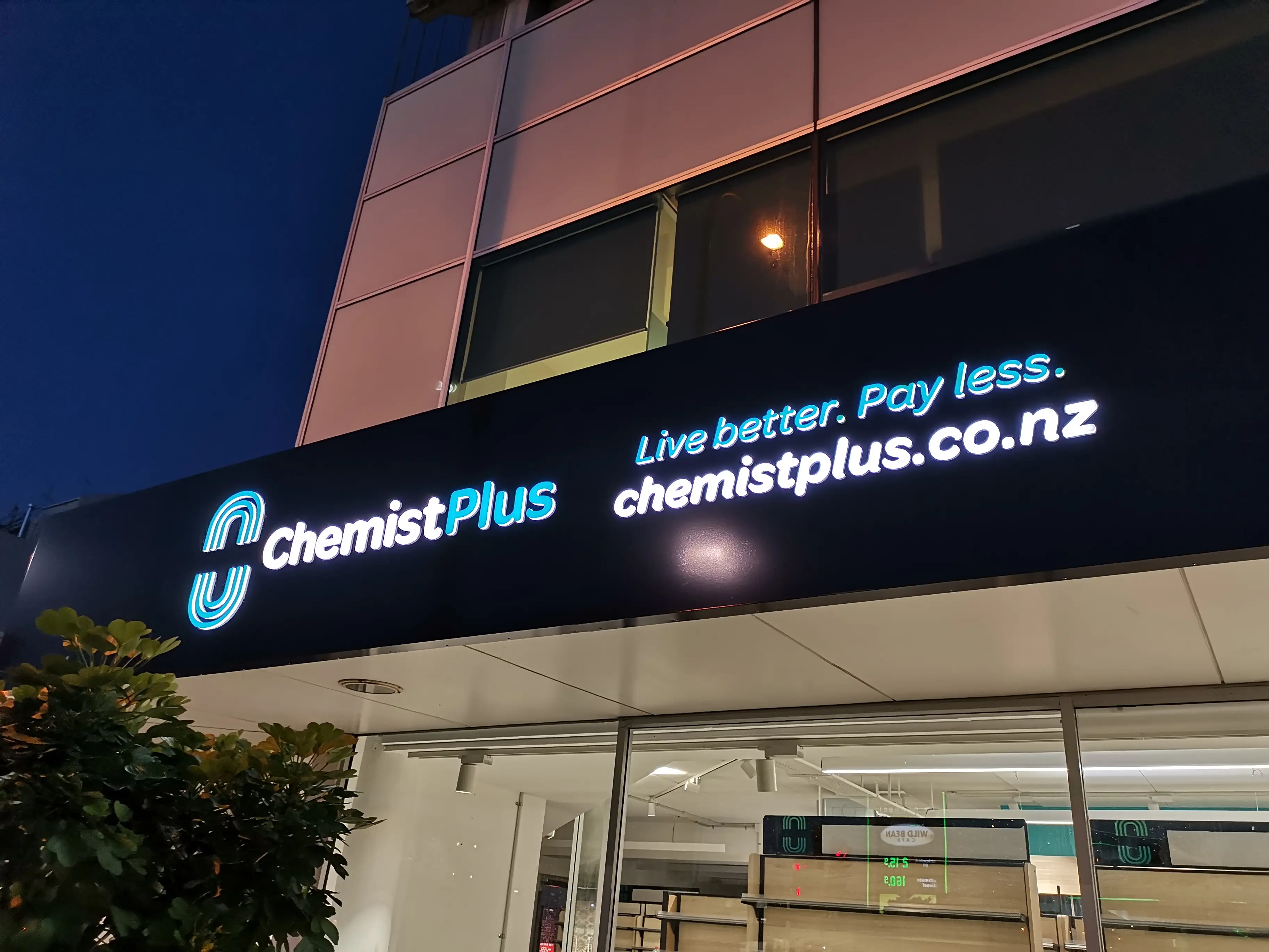 Chemist Plus retail interior with overhead brand signage.