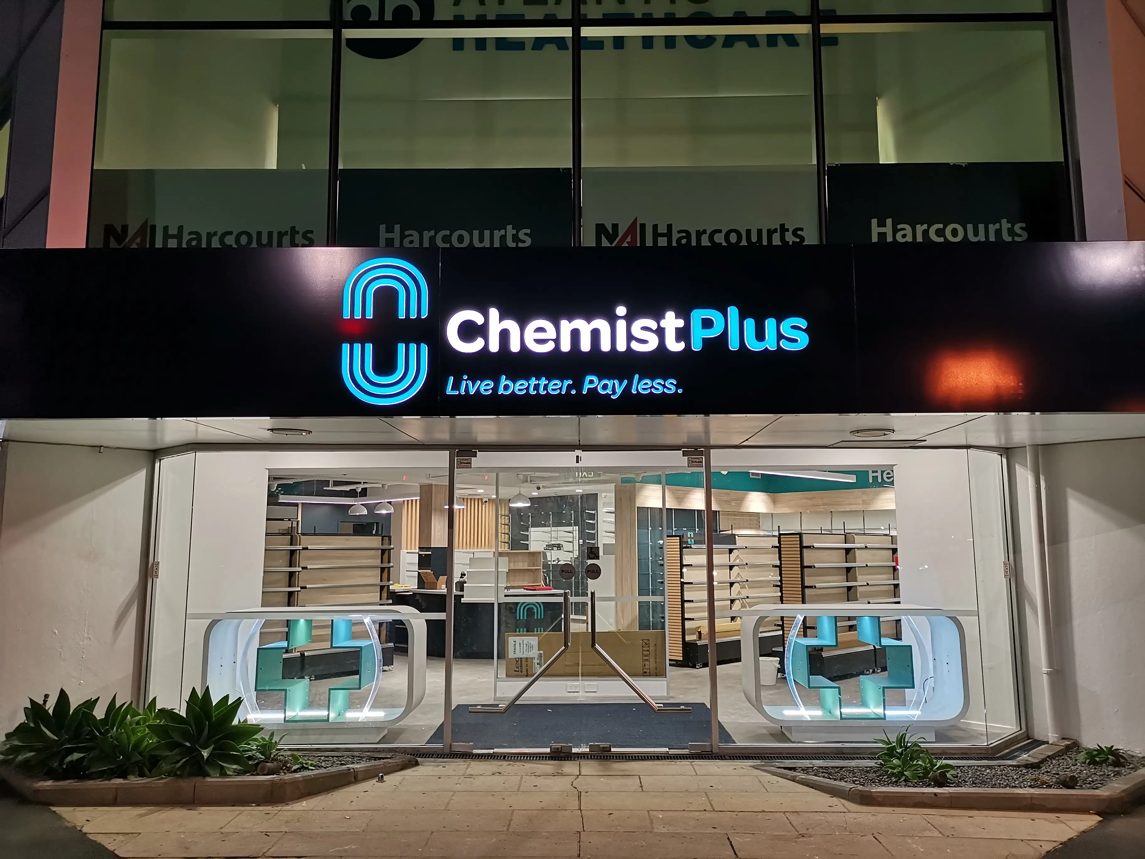 Chemist Plus retail interior with overhead brand signage.