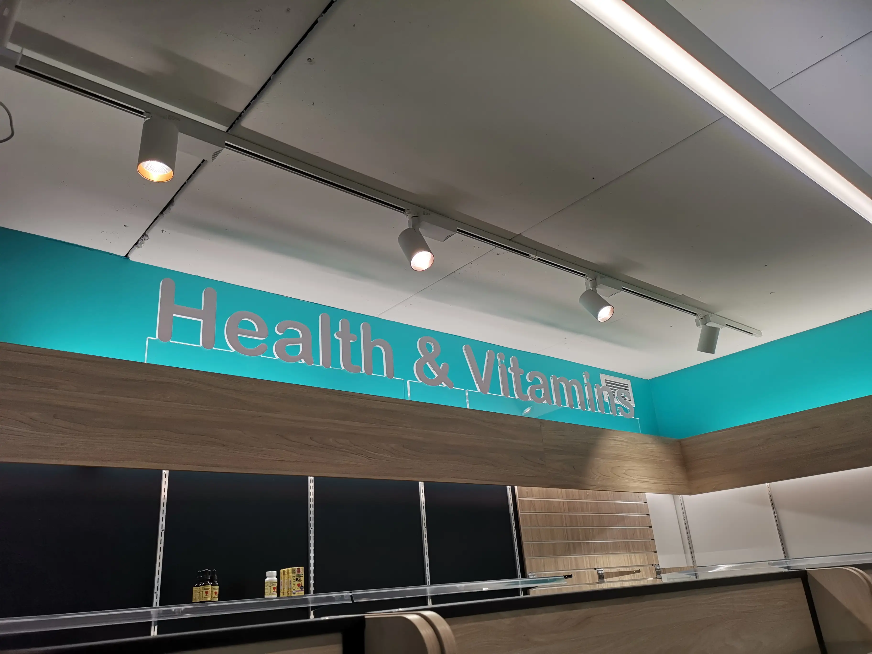 Illuminated pharmacy identity at the shopfront.