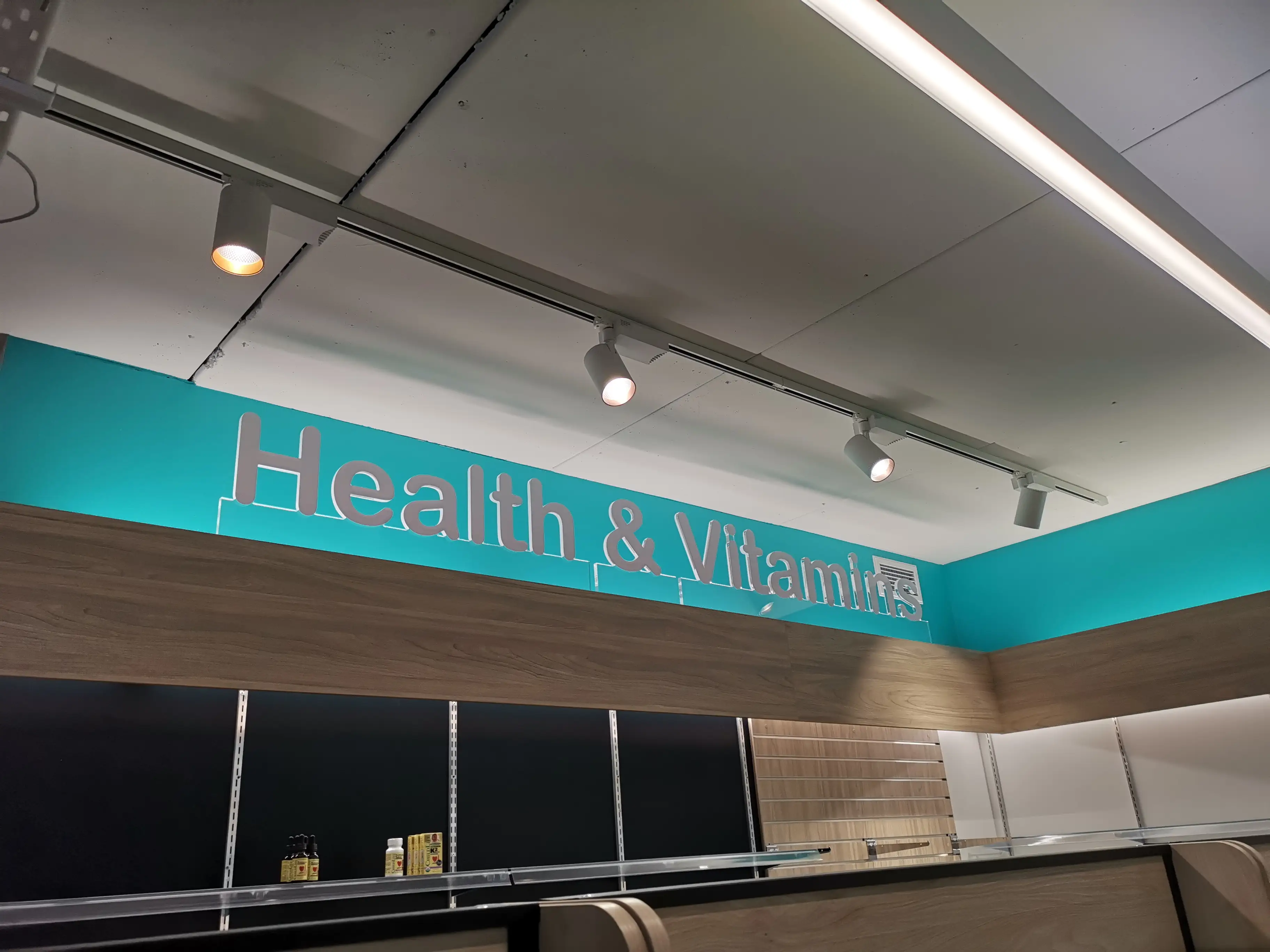 Chemist Plus retail interior with overhead brand signage.