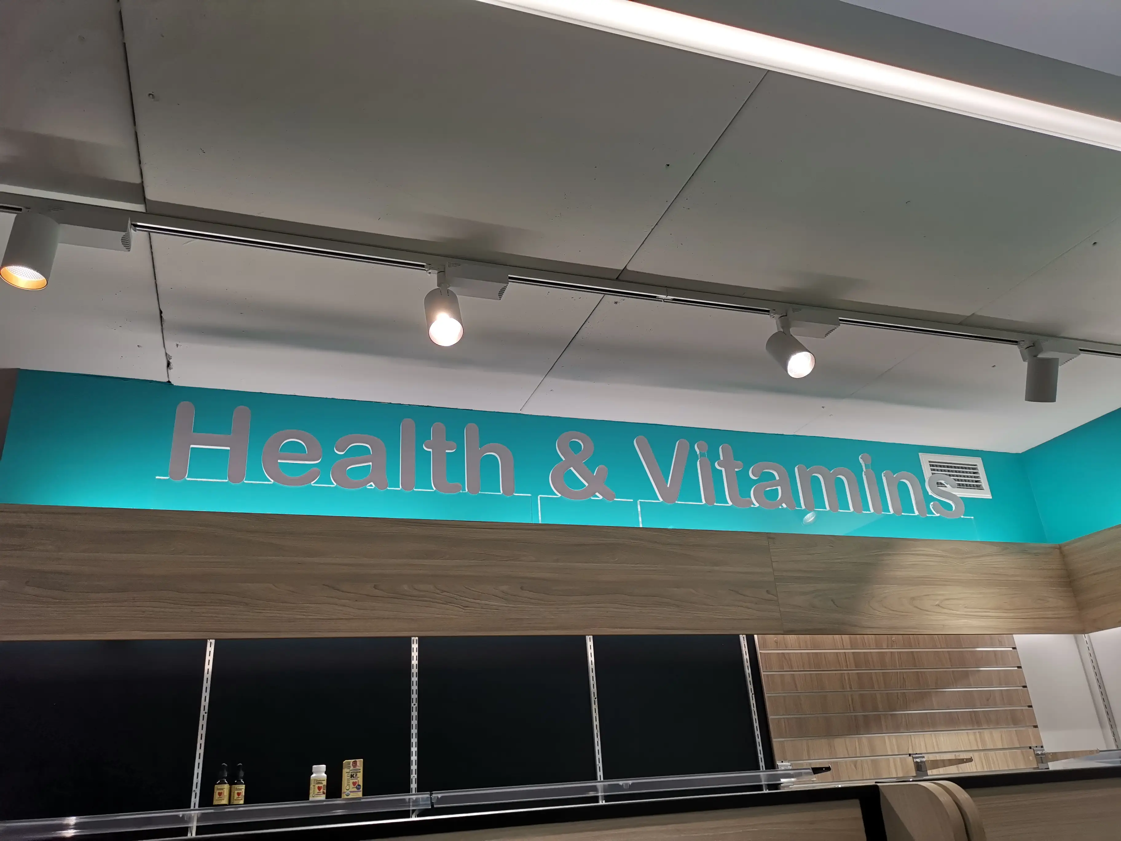 Illuminated pharmacy identity at the shopfront.