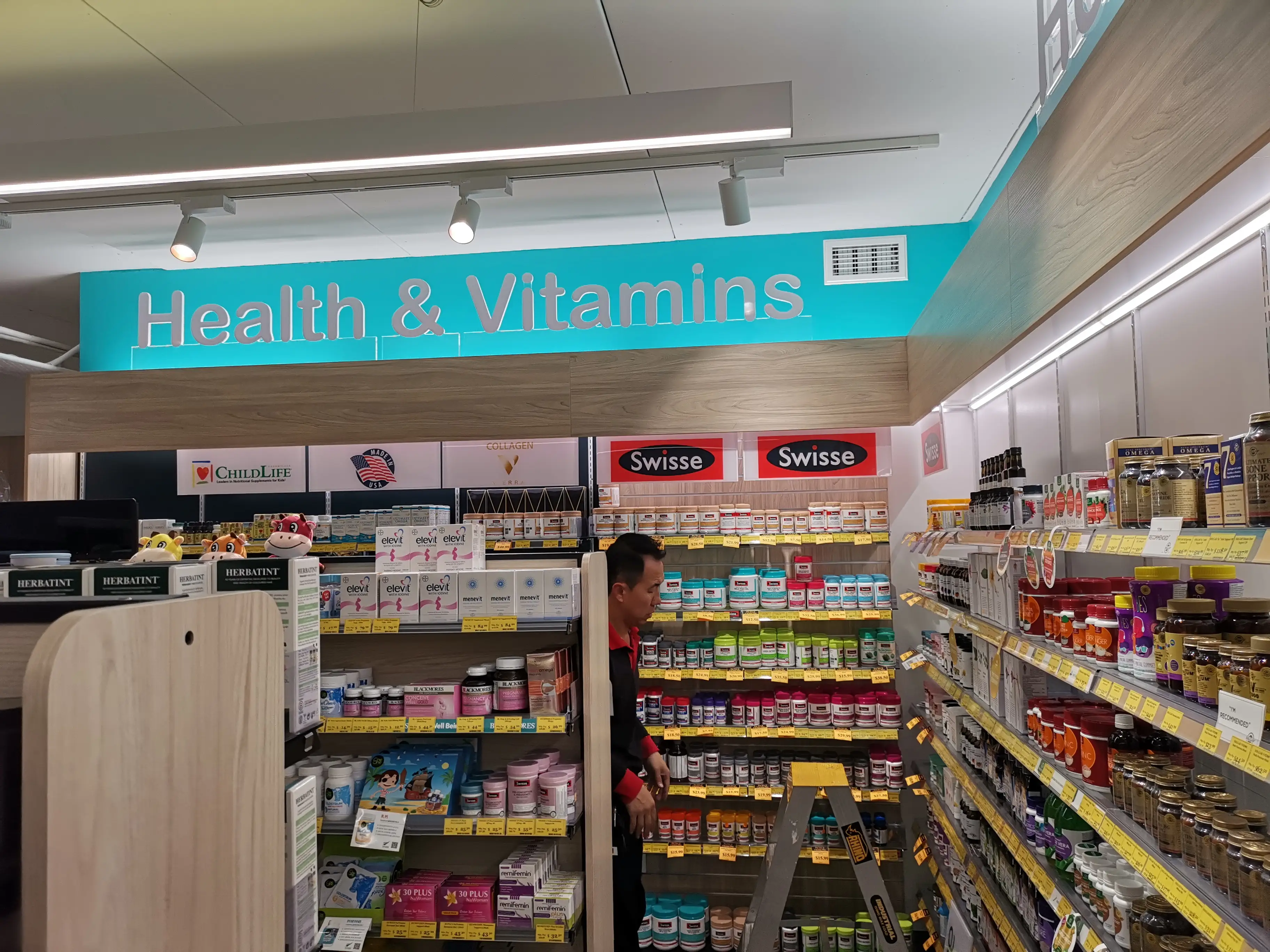 Chemist Plus retail interior with overhead brand signage.