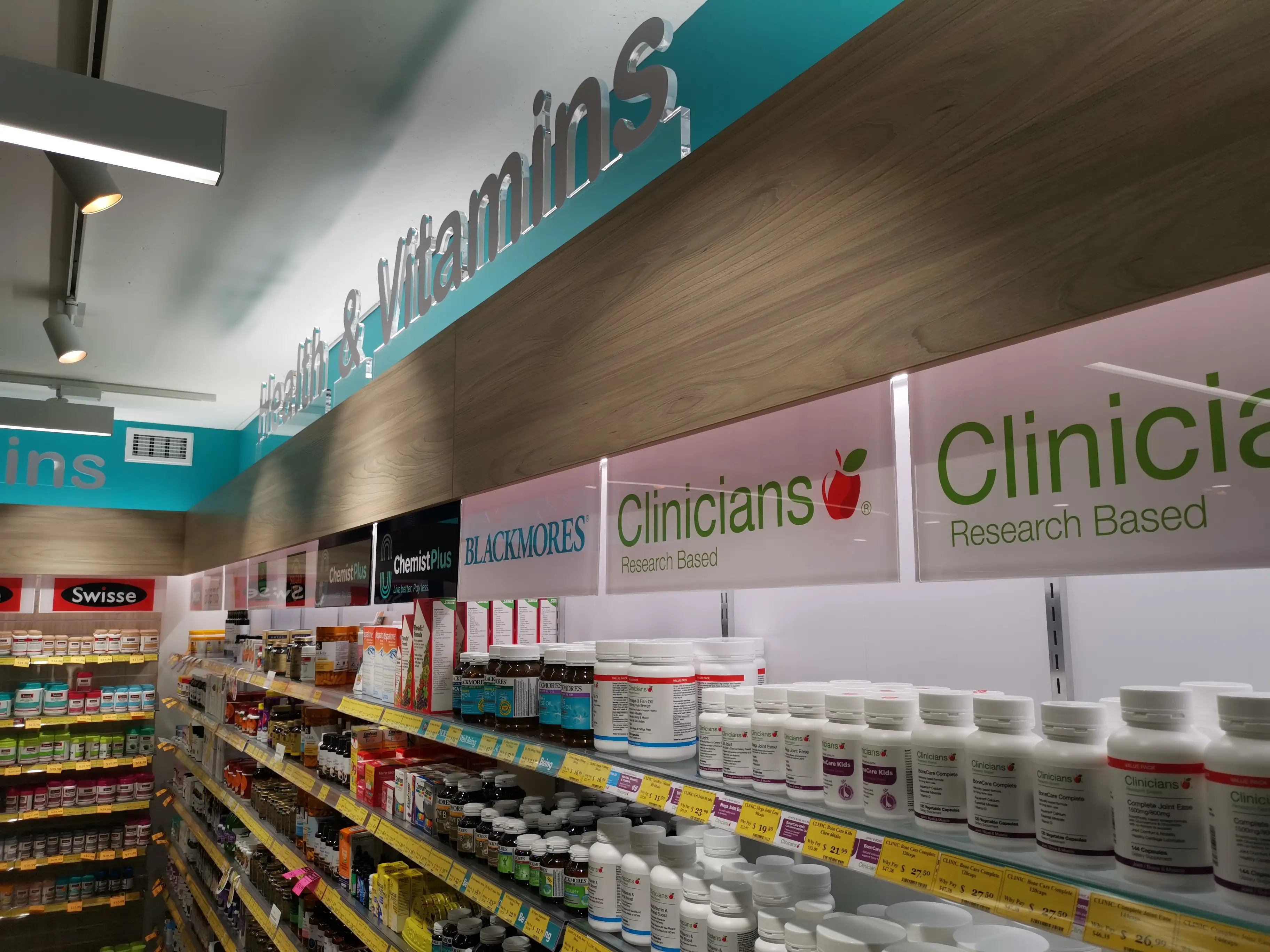 Illuminated pharmacy identity at the shopfront.