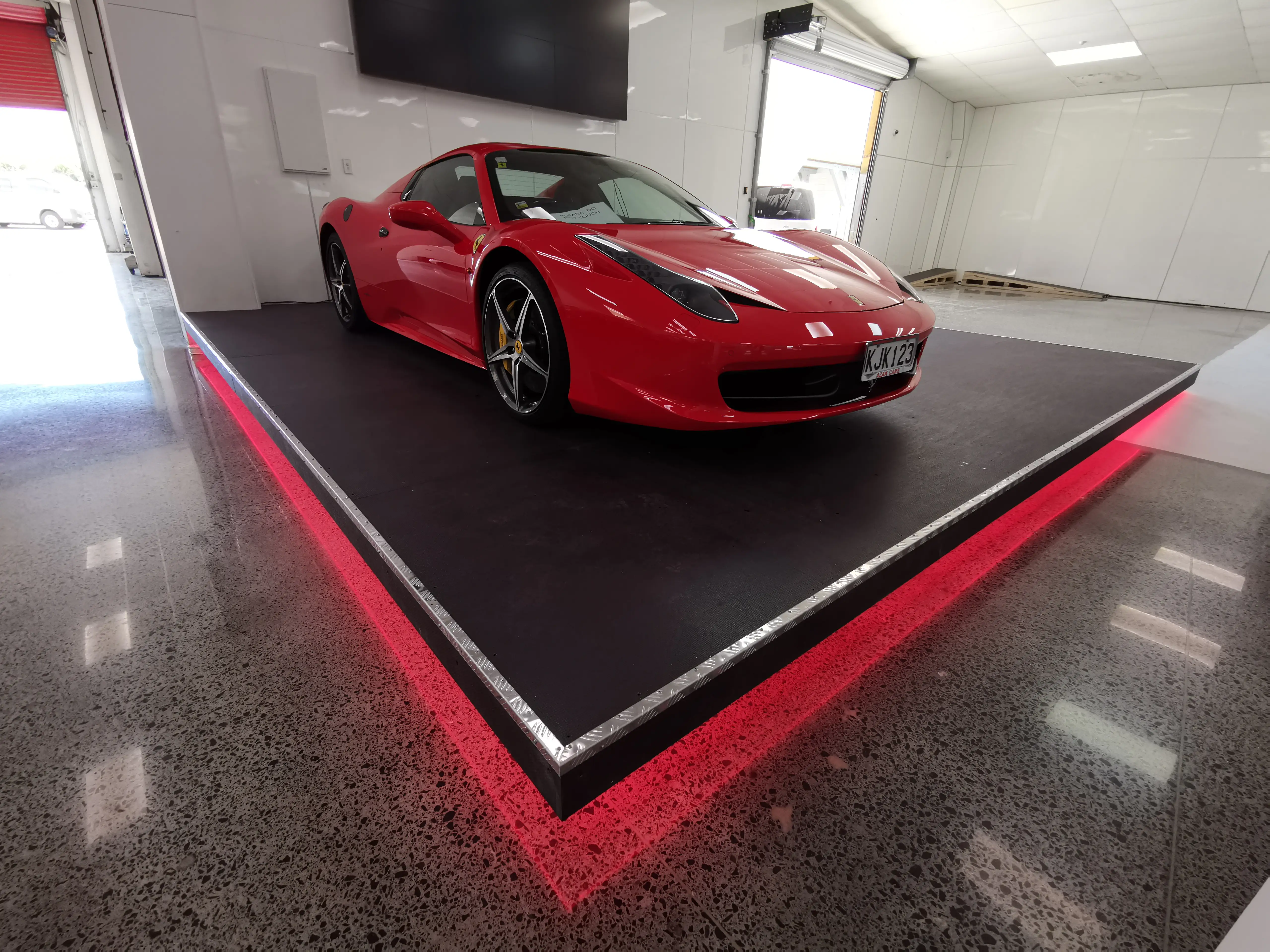 AZAK Cars showroom with linear ceiling lighting and a reflective floor.