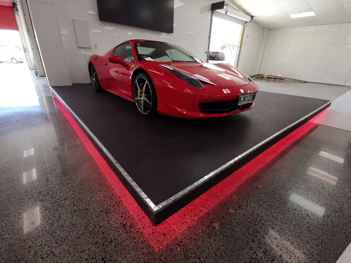 AZAK Cars showroom with linear ceiling lighting and a reflective floor.