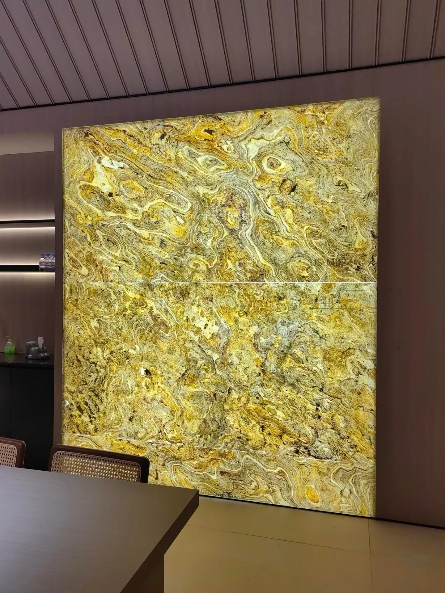 Large backlit natural stone feature wall in a commercial meeting space