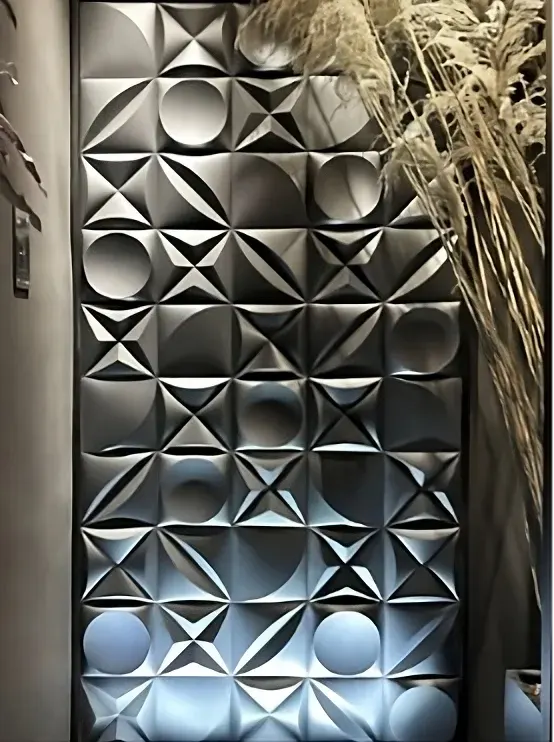 Dark geometric three-dimensional wall tiles lit to emphasise relief and shadow