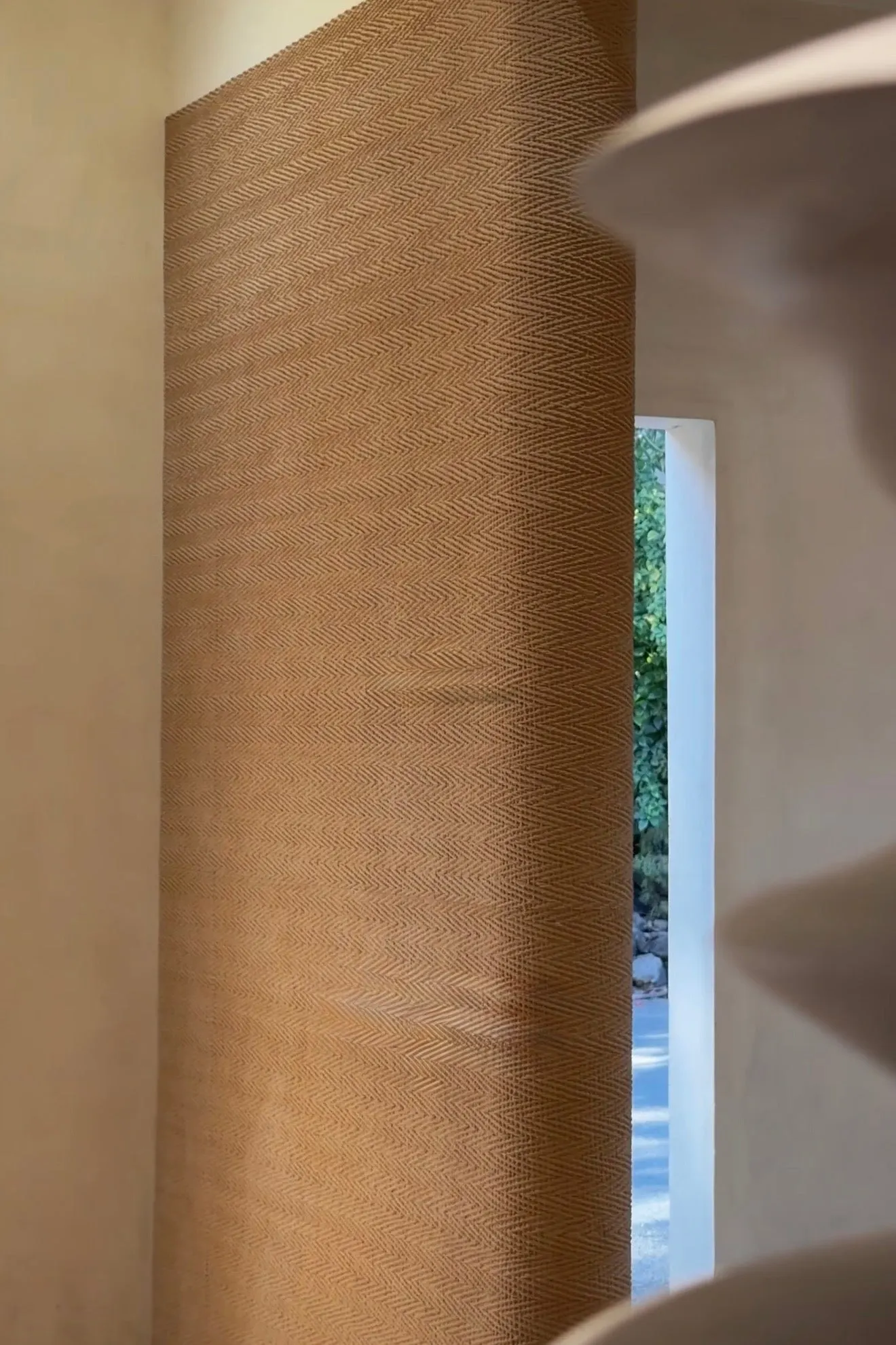 Woven textured wall finish wrapping a softly curved interior feature wall